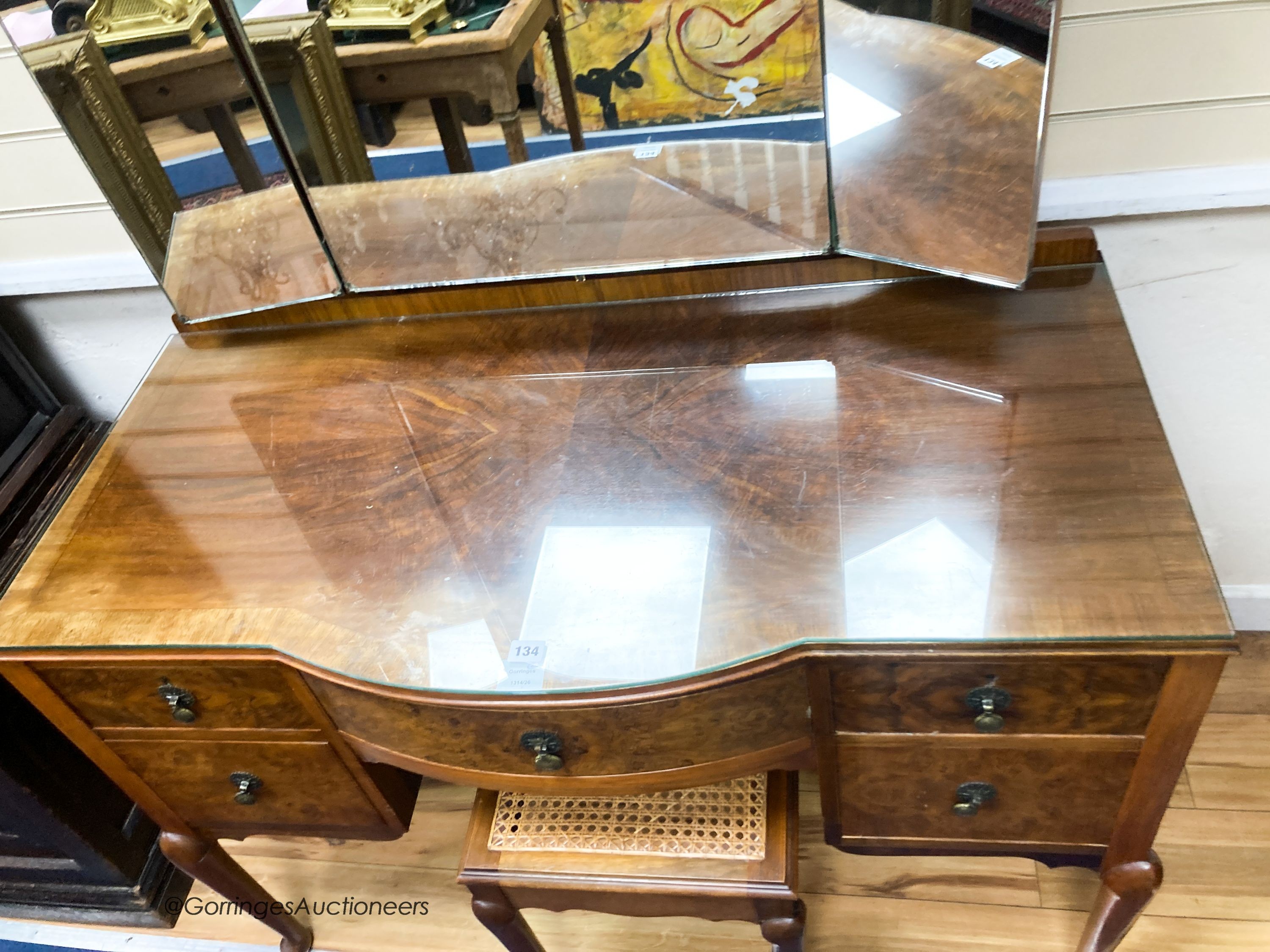A 1930’s burr walnut dressing table, width 114cm, depth 52cm, height 160cm and a cane topped stool (2)